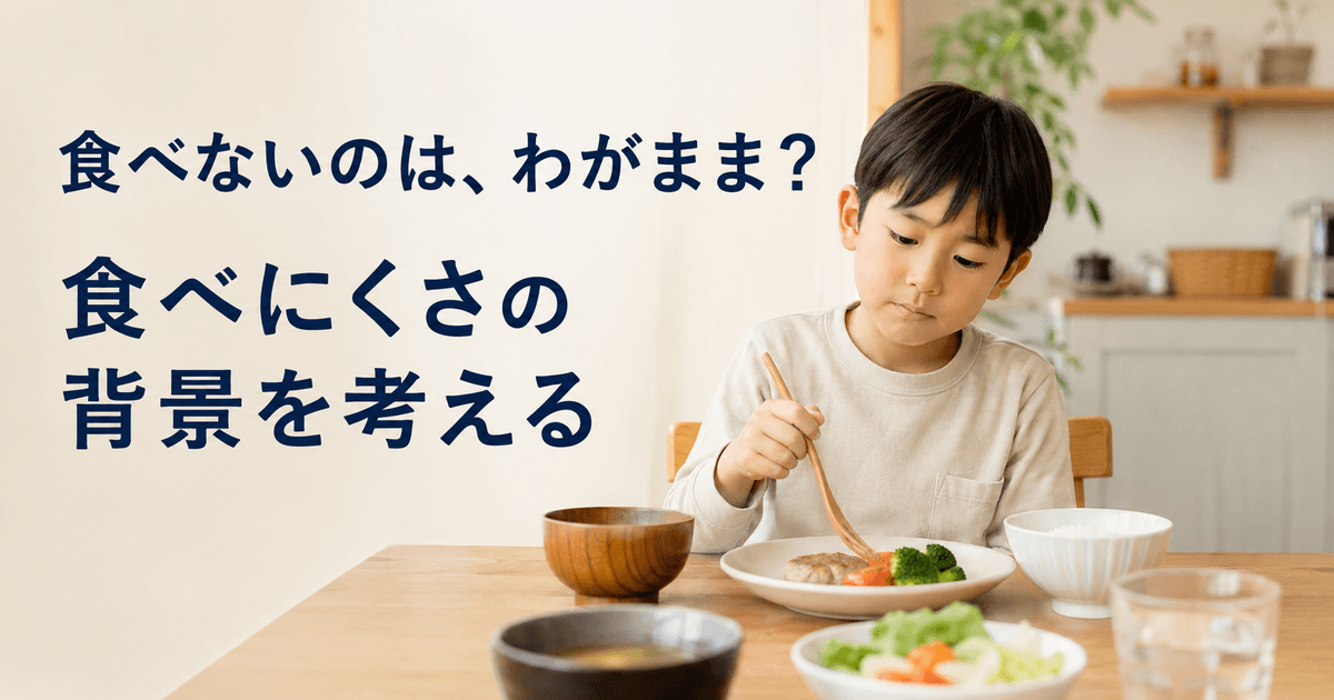 家庭の食卓で料理を前に、スプーンを持ちながら少し考えるように座っている子ども